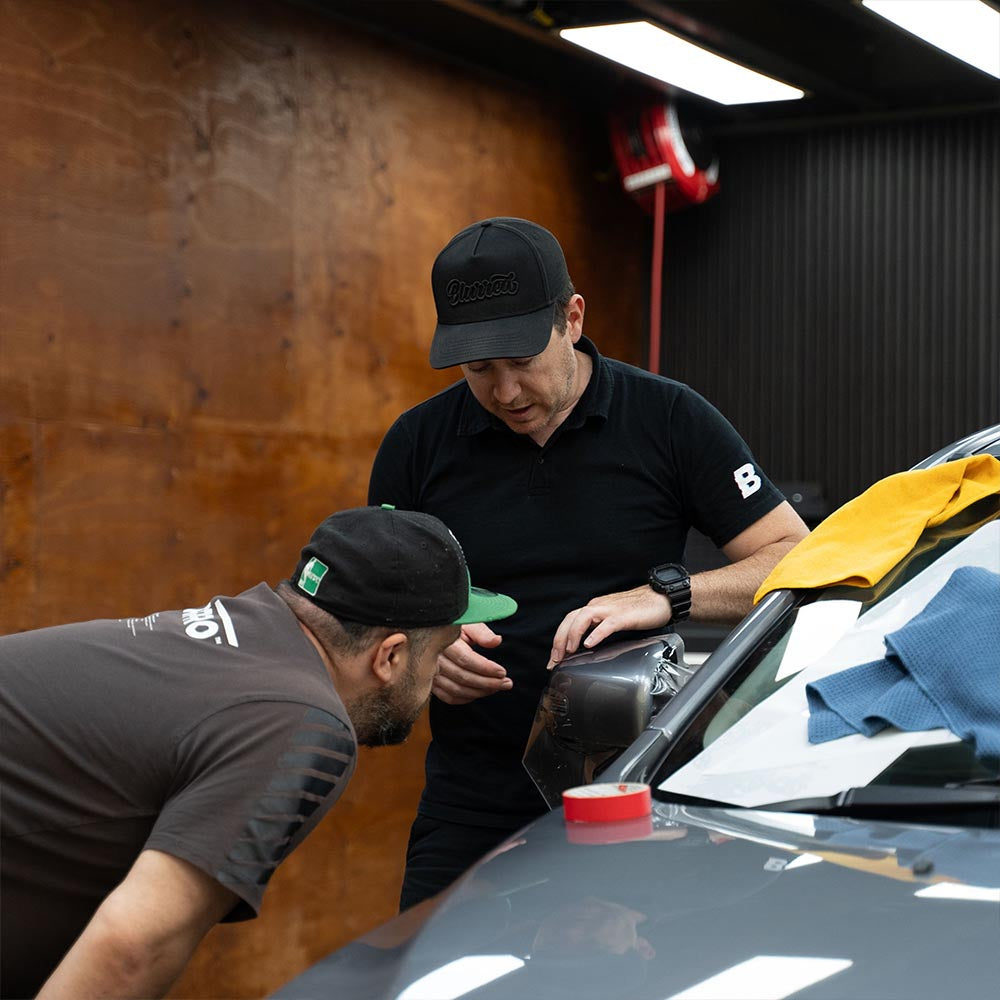 Teacher from the PPF course showing a student how to apply PPF