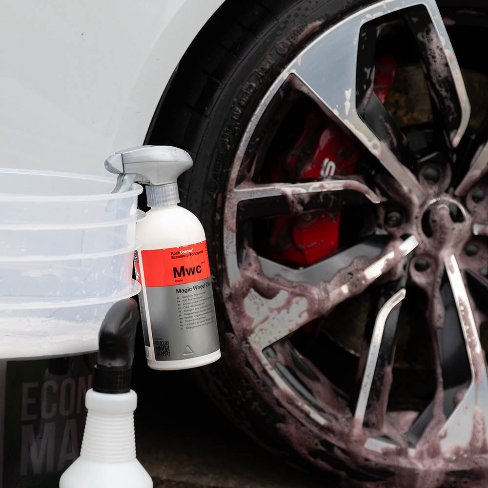 Koch Chemie Magic Wheel Cleaner 500 mL bottle on a wash bucket, sprayed on a wheel behind