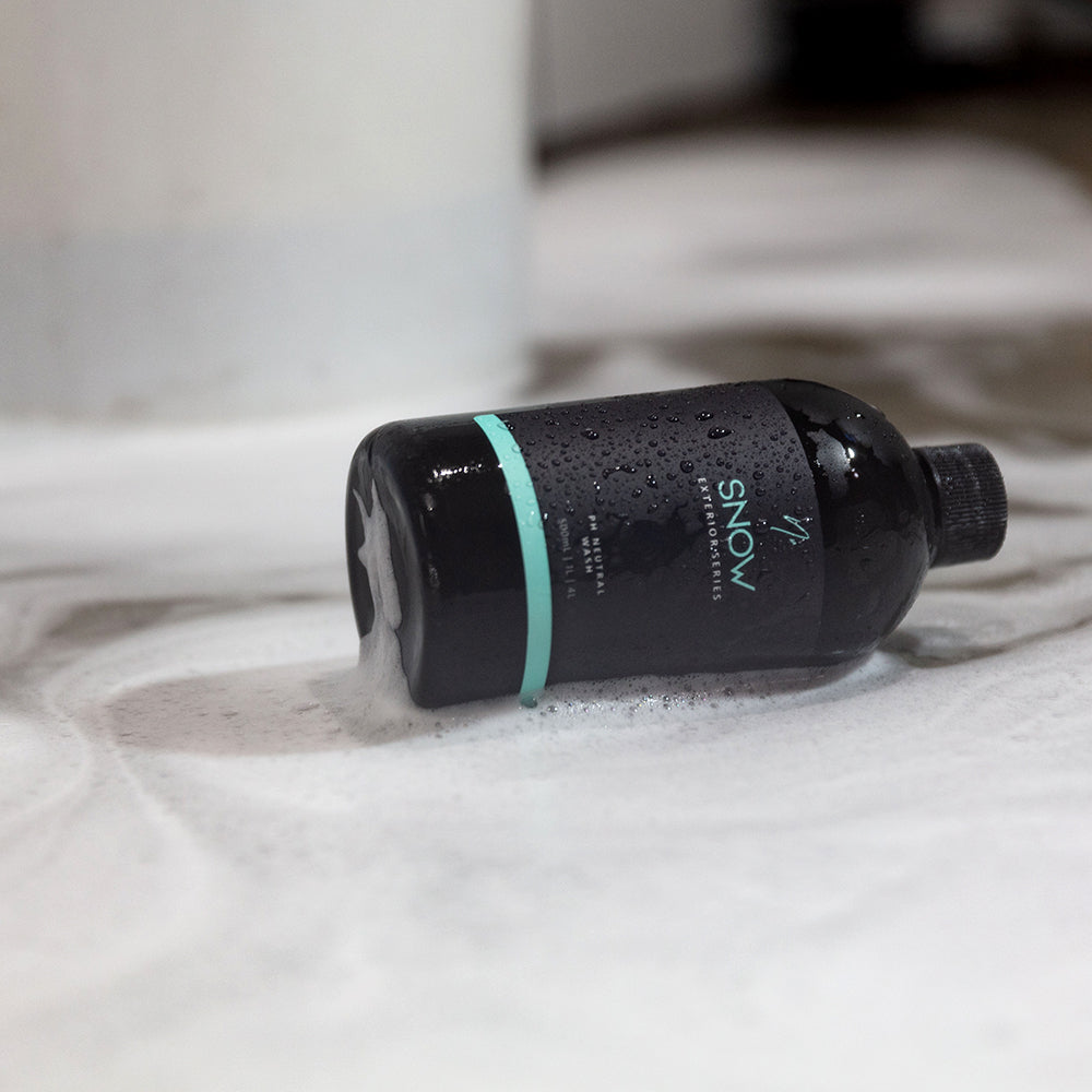 Nv SNOW 500 mL bottle lying in snow foam