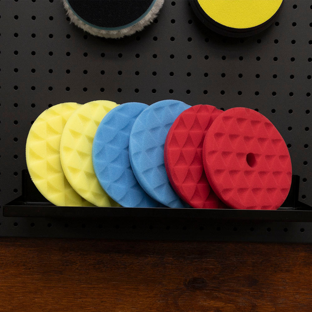 ShineMate blue, red and yellow foam pads on a shelf