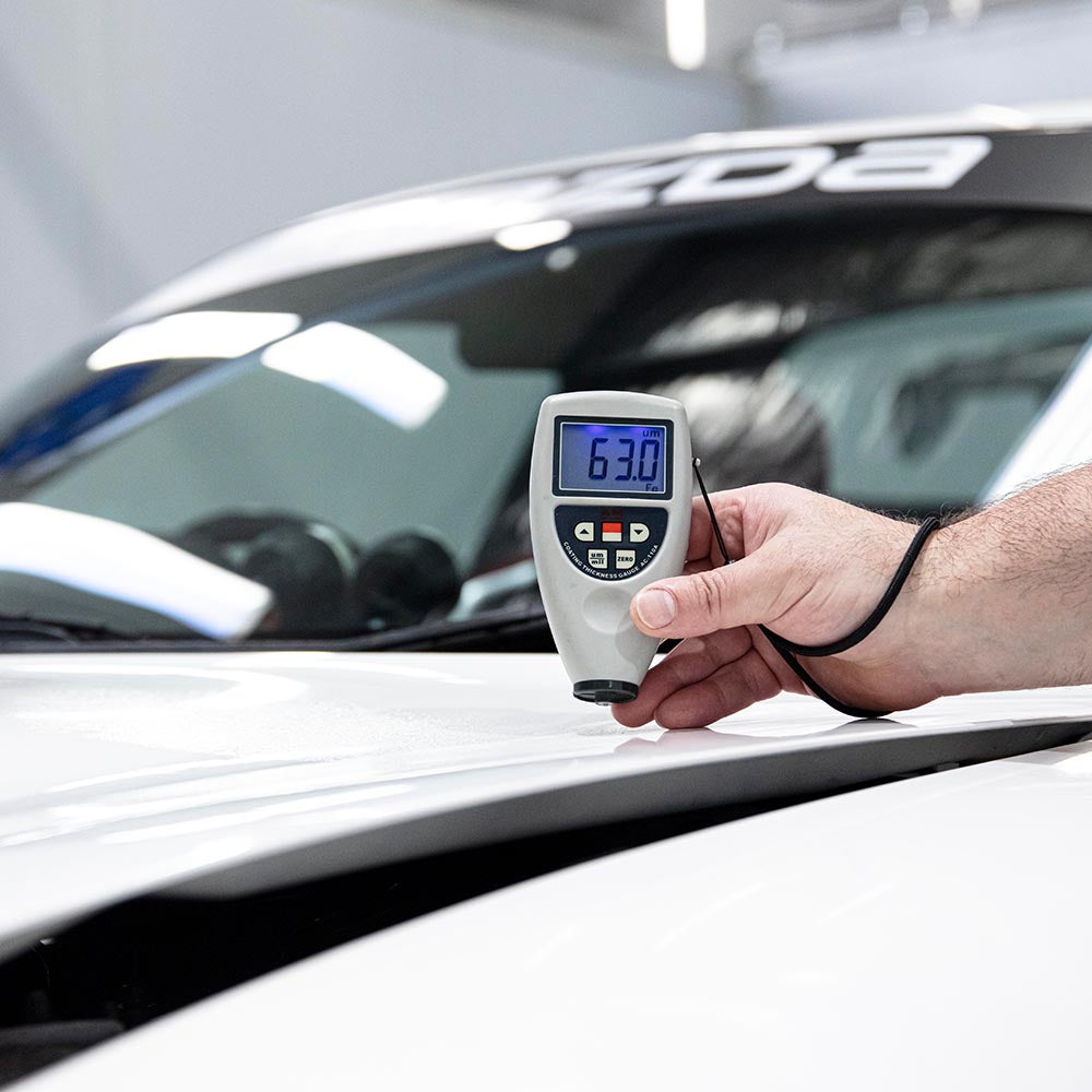 Economax Paint Thickness Gauge measuring paint on a car panel