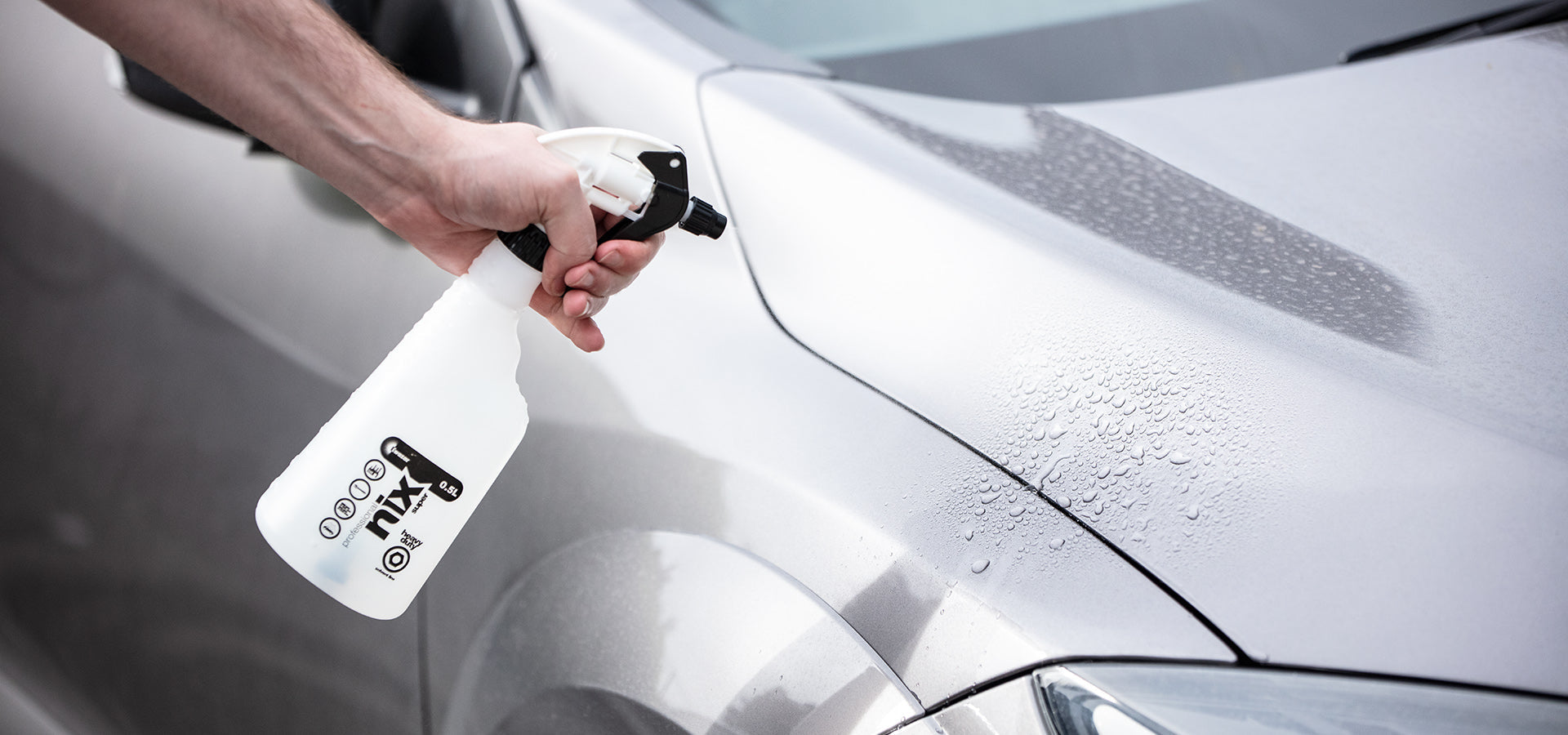 Spraying waterless wash solution on a car
