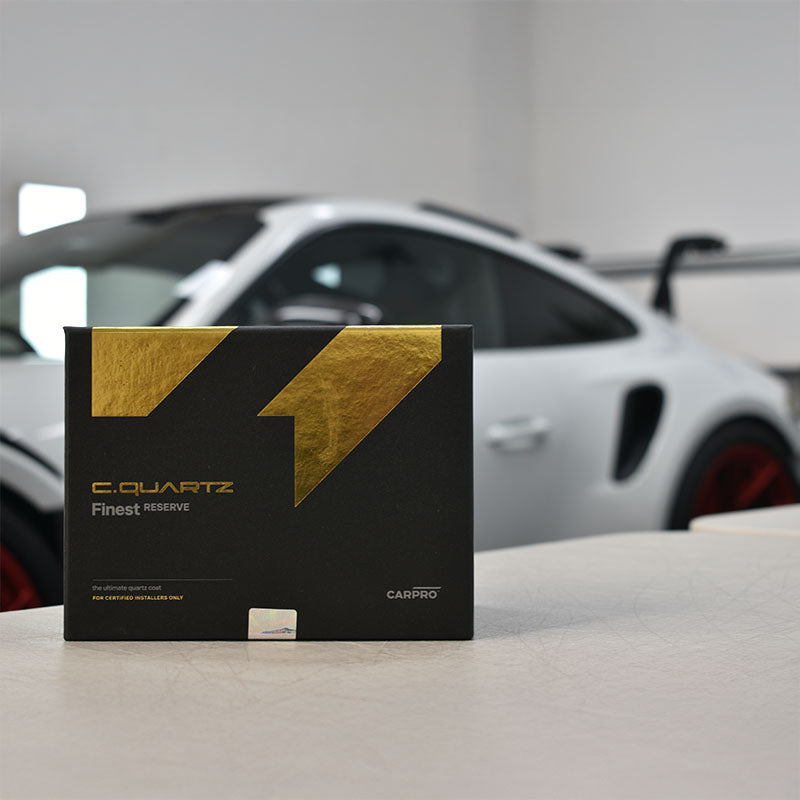 CARPRO Finest Reserve on a bench infront of white car