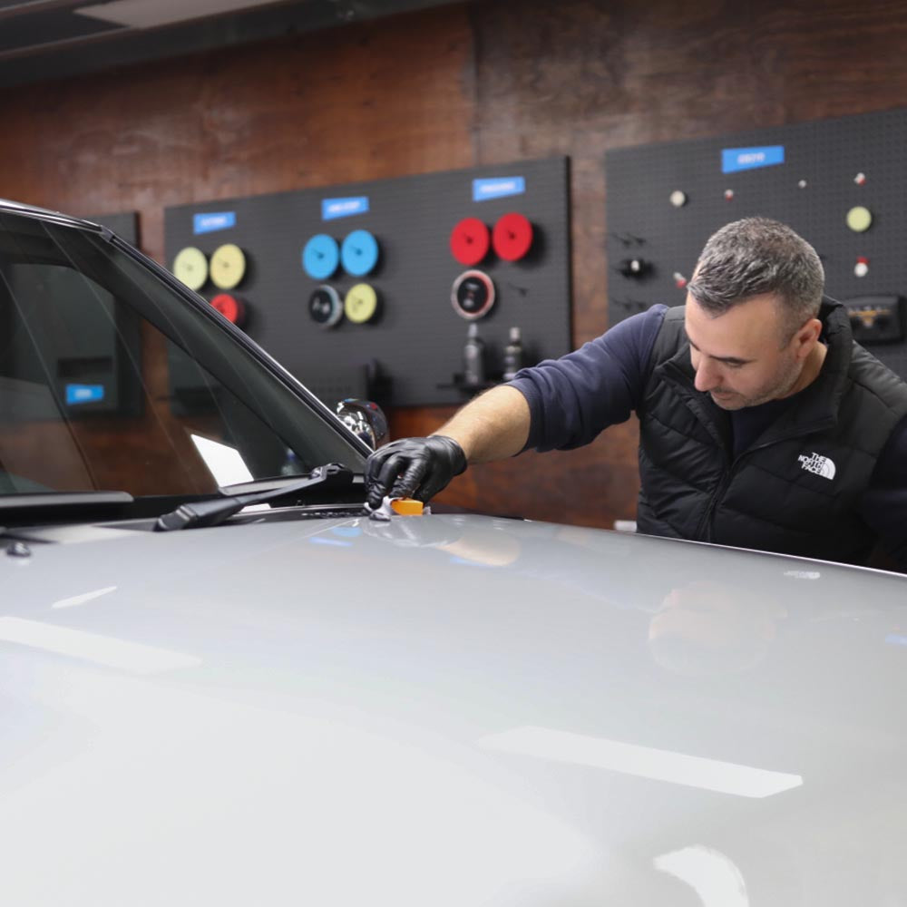 Someone from the training coating a silver car