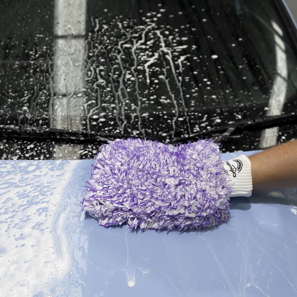 Hand washing a blue car with the Aquatouch BOSS wash mitt