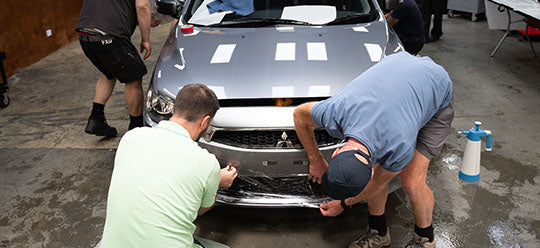 A group class applying PPF on a car