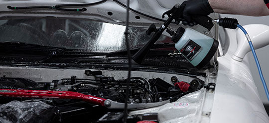 A person using a Tornador to clean an engine bay