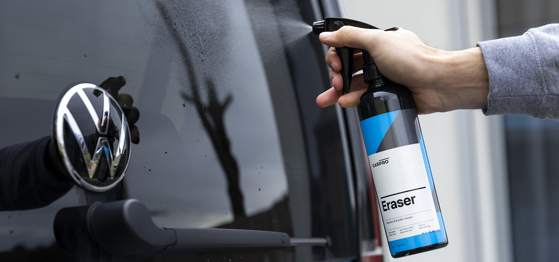 Spraying CaRPRO Eraser on the back windscreen of a car