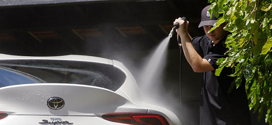 Person washing a white Toyota Supra with an Annovi Reverberi high-pressure bent lance